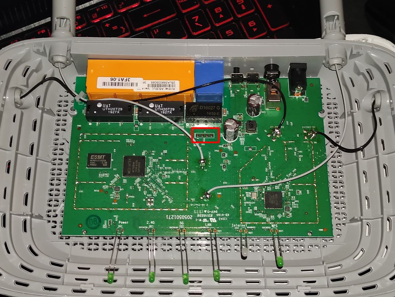 The opened Archer A5 board. The red box marks the four-pin UART serial header next to the power circuitry, the pads this whole teardown turns on. Also visible: the MediaTek MT7628 SoC (the large central chip), the ESMT DDR RAM to its left, two U&T ethernet magnetics, the 5 GHz radio, and the LED light-pipes with their silkscreen labels (Power, 2.4G, 5G, LAN, Internet, WPS) along the bottom